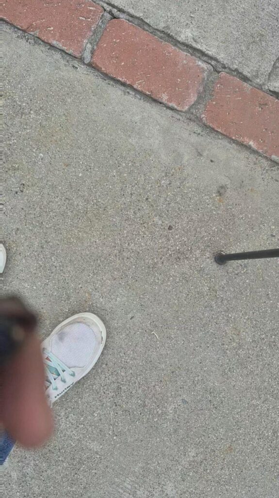 白い靴を履いて歩道を歩く足元と杖