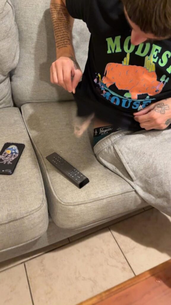 服から落ちる薄ピンク色のハムスター