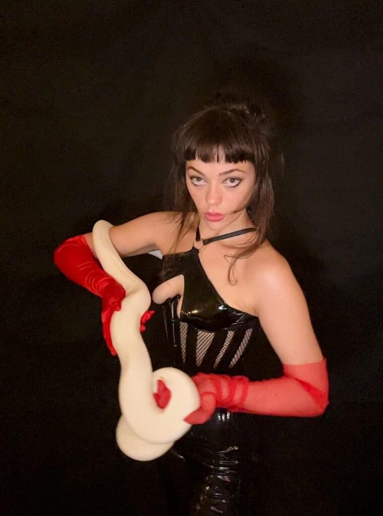 白いヘビを抱えている女性