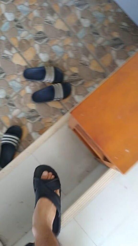 人間が黒いサンダルを履いて立っている